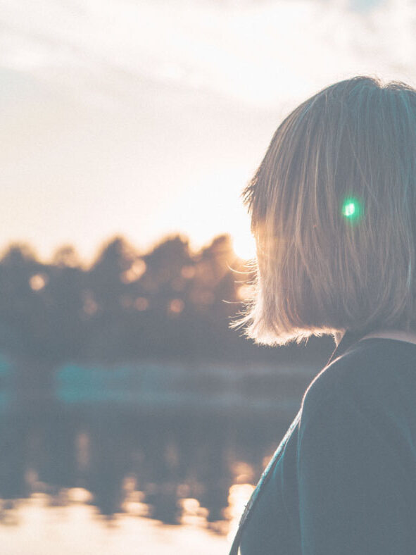 Frau blickt auf See und Sonnenuntergang – Mood Foto Entspannung und Regeneration